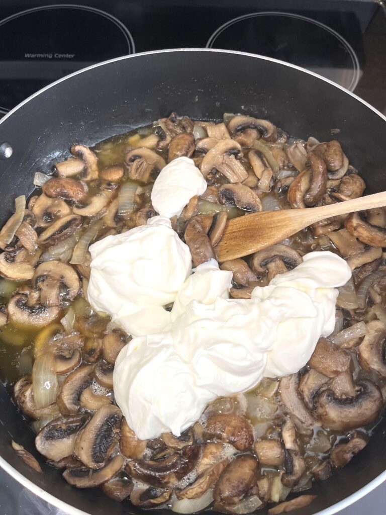 adding sour cream into mushroom sauce