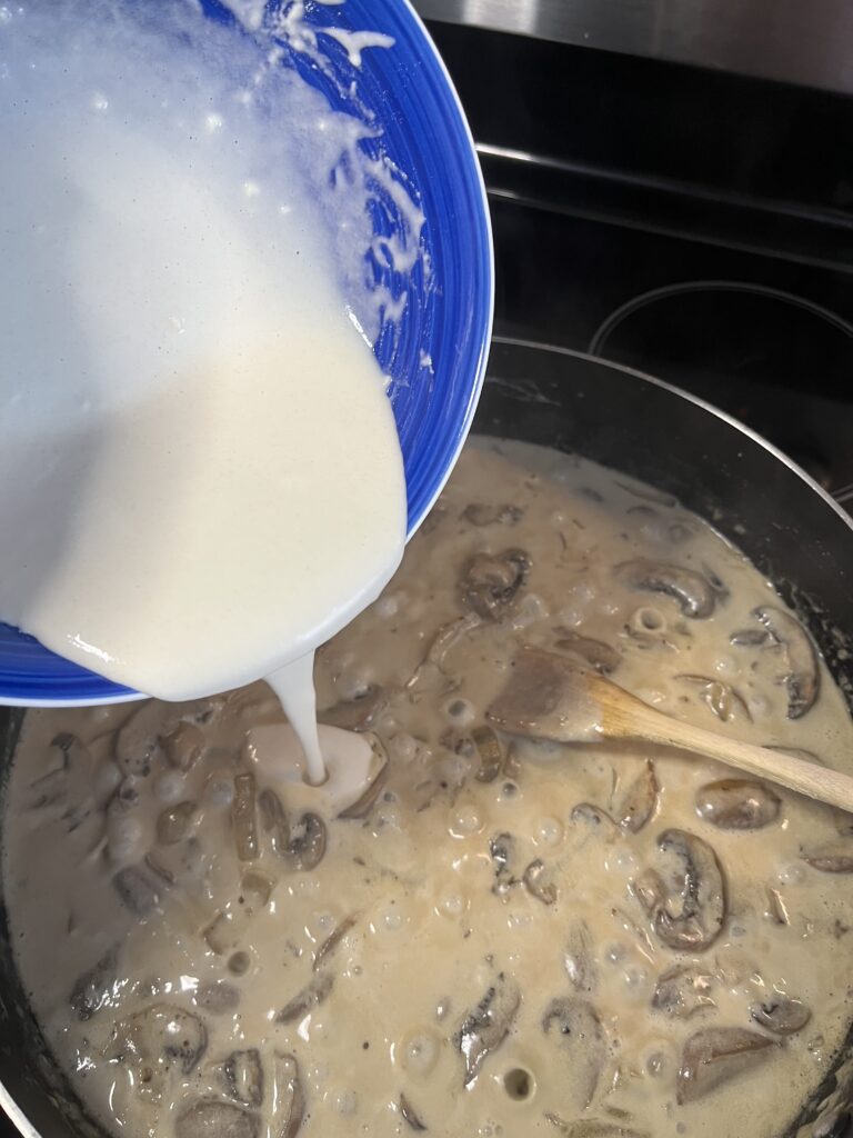 sour cream poured into the mushroom sauce