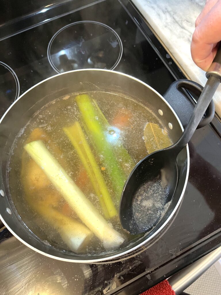 removing white foam from Polish mushroom soup aka zupa grzybowa