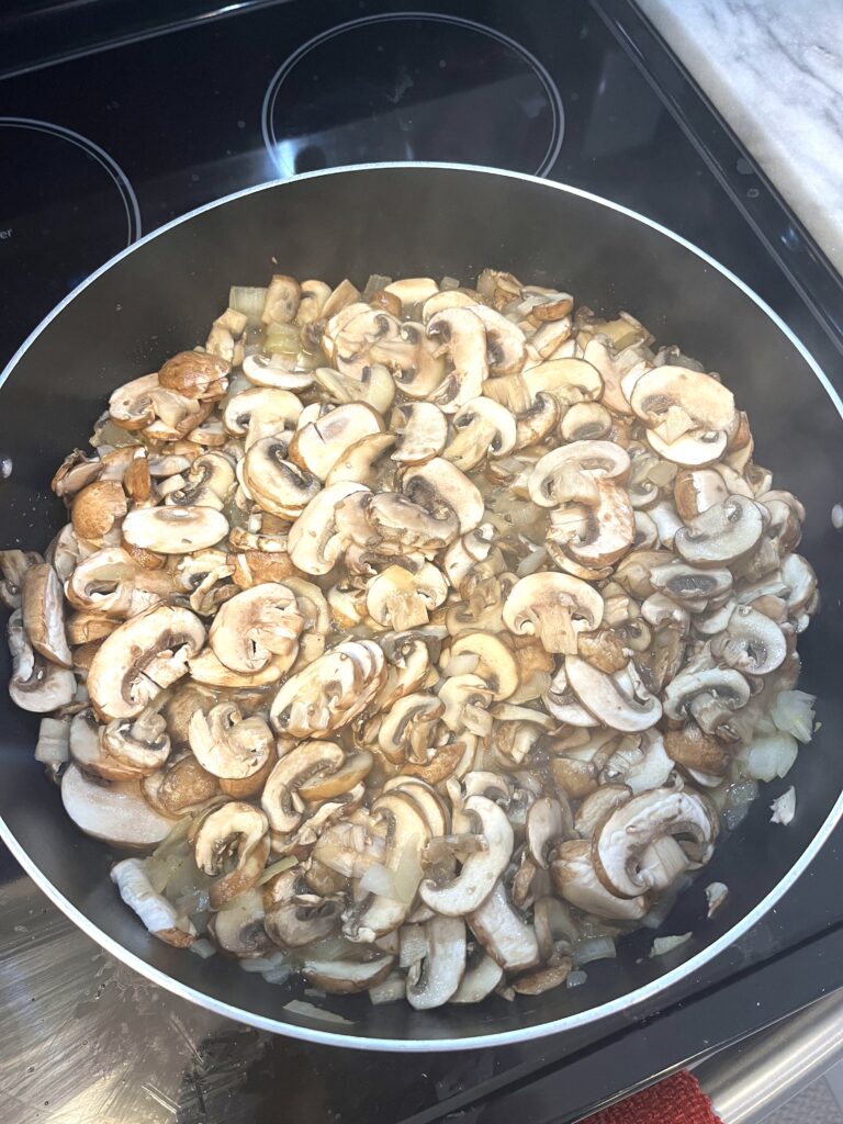 Mushrooms and onions in the frying pan for Polish mushroom soup aka zupa grzybowa