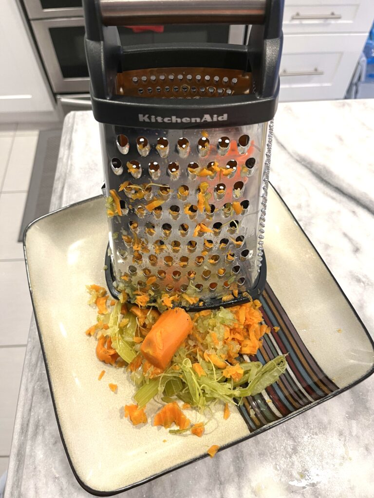 grating carrots for Polish Sauerkraut Soup aka Kapusniak