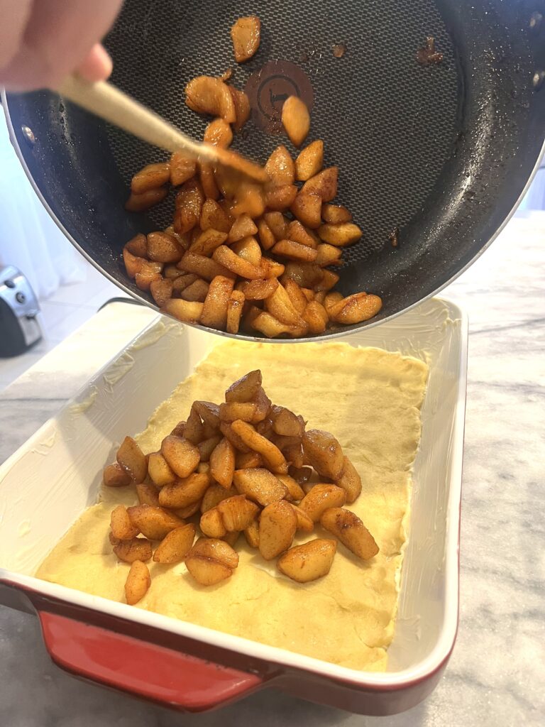 transferring fried apples to pan for Polish apple pie aka Szarlotka