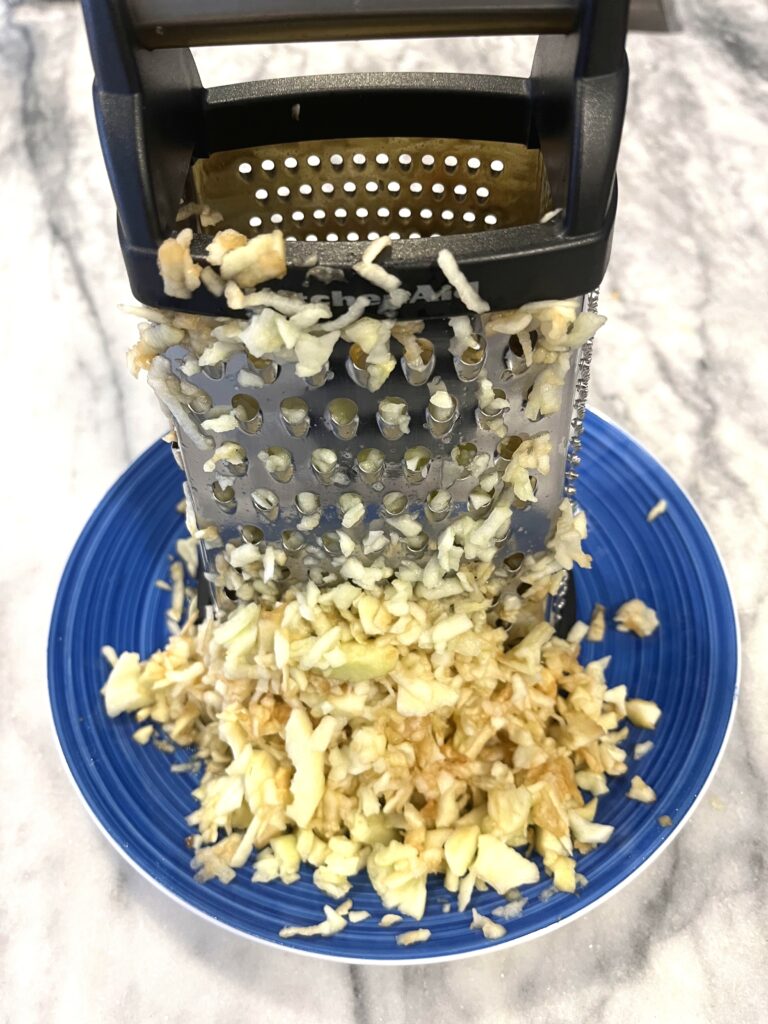 grating apples for Polish apple pie aka Szarlotka